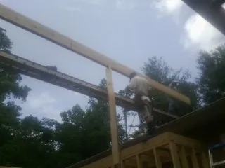 Carpenter setting a ridge beam over a new addition frame — Ice Dam Removal by Roofing Brothers in Fort Atkinson