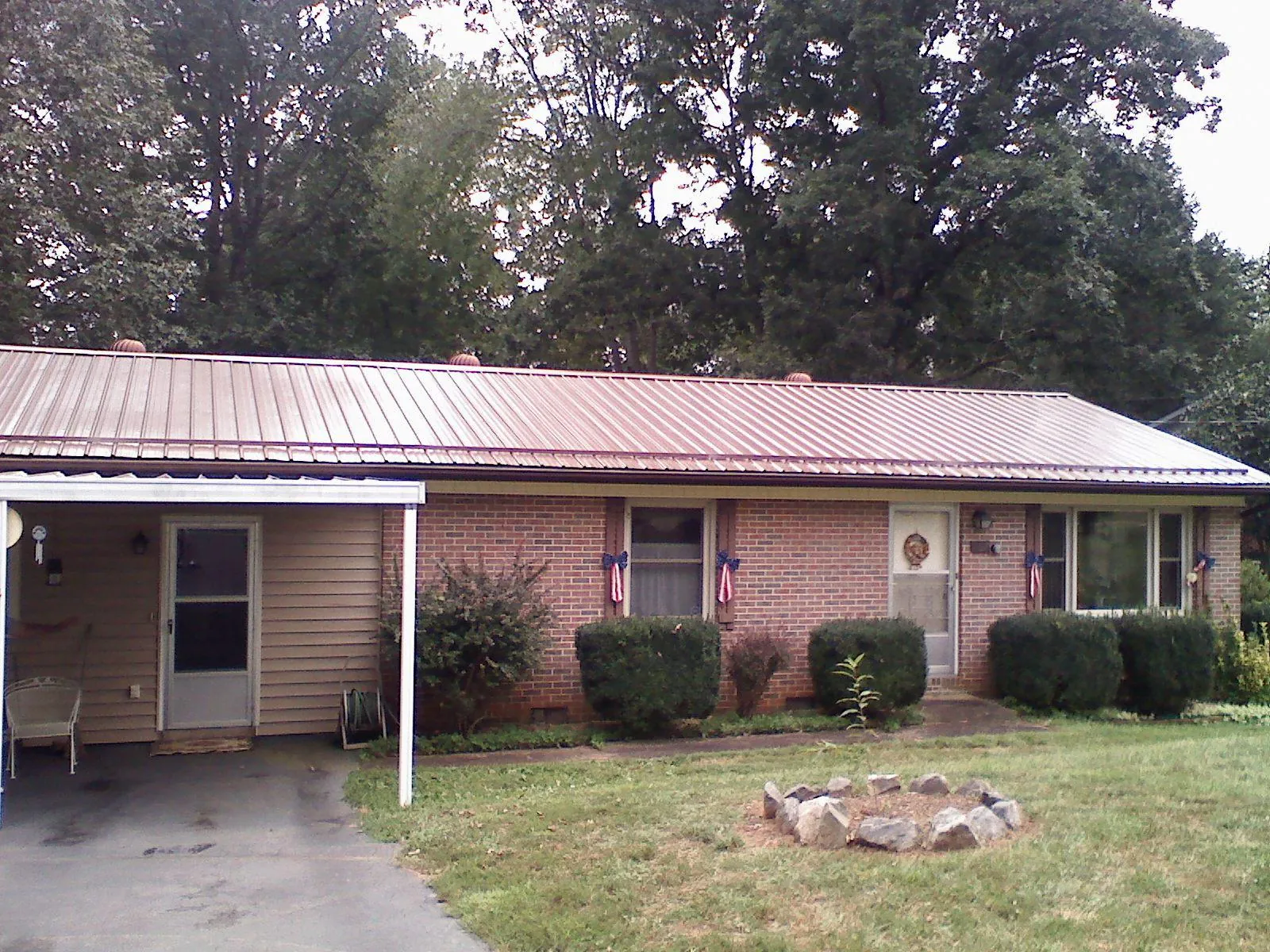 Bronze metal roof and carport on a brick ranch home — Roof Repair work by our crew in Fort Atkinson